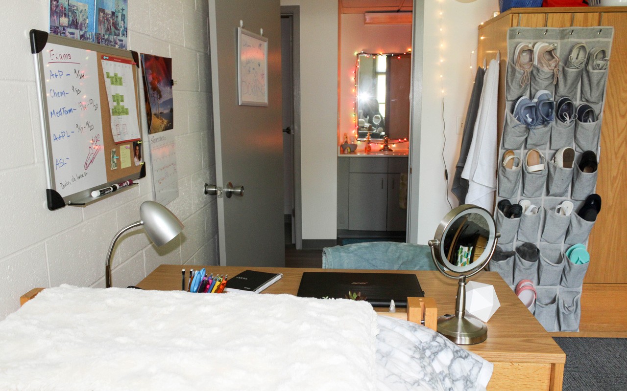 Bed, desk, wardrobe closet, and door to a double bedroom in a quad room in Turner Hall.